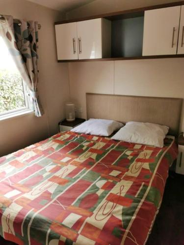 une chambre avec un lit avec une courtepointe colorée dessus dans l'établissement Bungalow confortable à Onzain avec piscine partagée, à Onzain