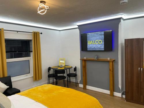 um quarto com uma cama amarela e uma mesa com cadeiras em Balco City Living em Nottingham