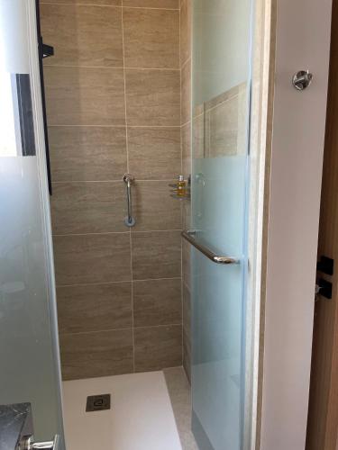 a bathroom with a shower with a glass door at Windhill Edge Villa in Pissouri