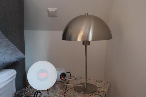 a lamp sitting on a table next to a bed at Ferienwohnung Habitat in Gaggenau