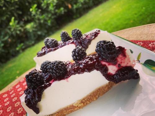 a piece of cake with blackberries on top of it at La Locanda Del Tevere in Fiano Romano