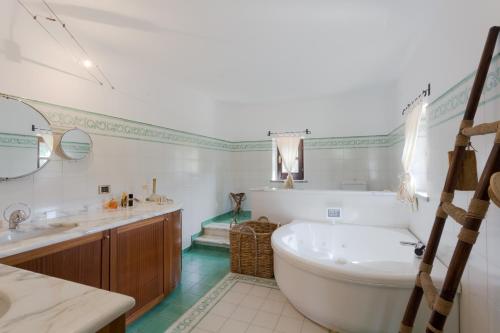 a bathroom with a large white tub and a sink at La Cicala in Beverino