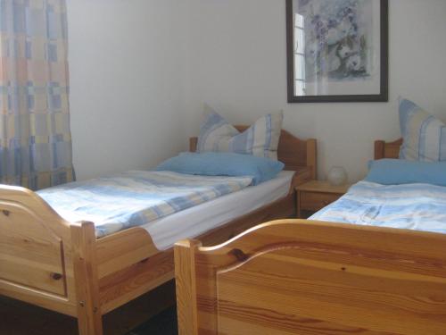 2 Betten in einem Zimmer mit blauen Kissen in der Unterkunft Haus ReWi in Bünde