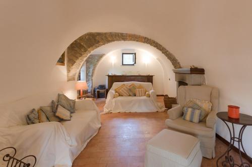 a living room with two white couches and a bed at La Cicala in Beverino