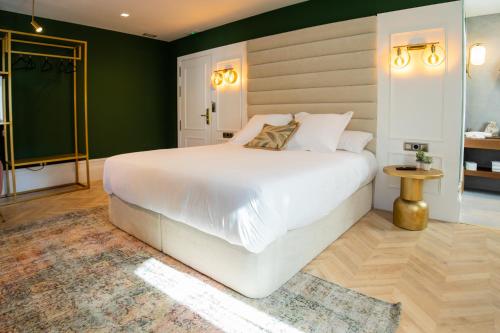 a bedroom with a white bed and green walls at Casa do Estanco in Quiroga
