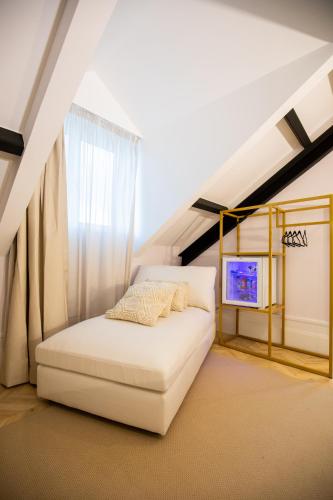 a bedroom with a white bed in a attic at Casa do Estanco in Quiroga