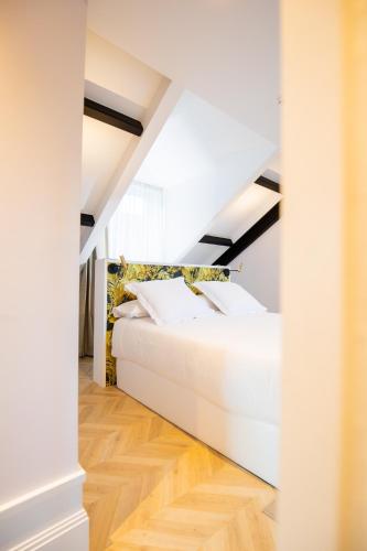 a bedroom with a white bed in a attic at Casa do Estanco in Quiroga