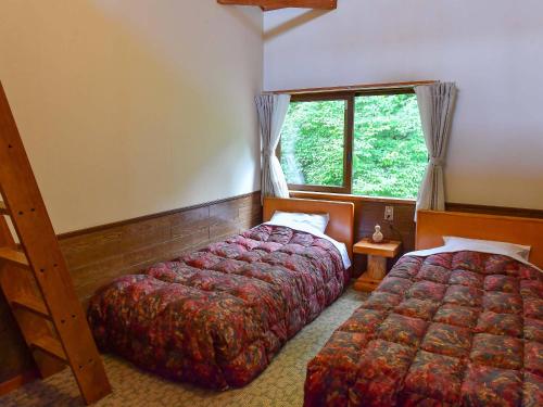 湯澤的住宿－趙酒店，一间卧室设有两张床和窗户。