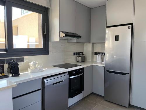a kitchen with white appliances and a window at Windhill Edge Villa in Pissouri