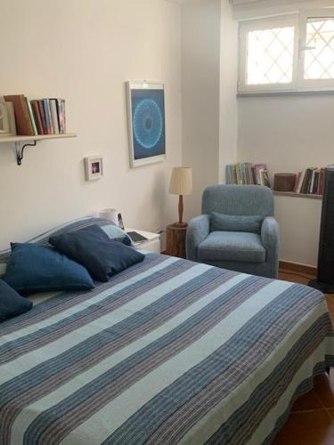 ein Schlafzimmer mit einem Bett, einem Stuhl und einem Fenster in der Unterkunft Casa Celeste Fregene, il mare di Roma in Fregene