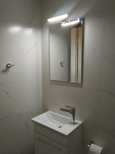 a bathroom with a sink and a mirror at Seaside luxury apartment in Analipsi