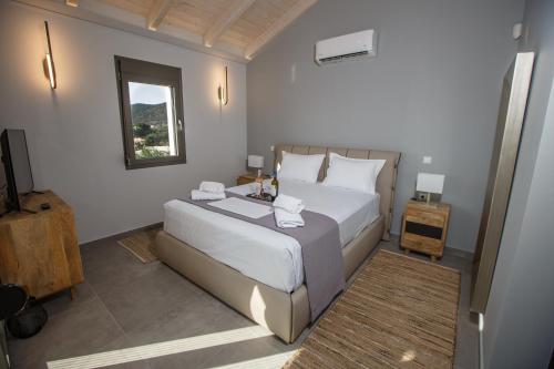 1 dormitorio con 1 cama grande y TV en Théa boutique villas sivota II, en Sivota