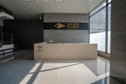 a lobby with a golden harrier sign on a wall at Golden Planet Hotel in Icheon