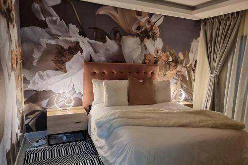 a bedroom with a bed with a wall with feathers at Koena Court Apartment 3 - With Uncapped Fiber Wi-Fi in Midrand