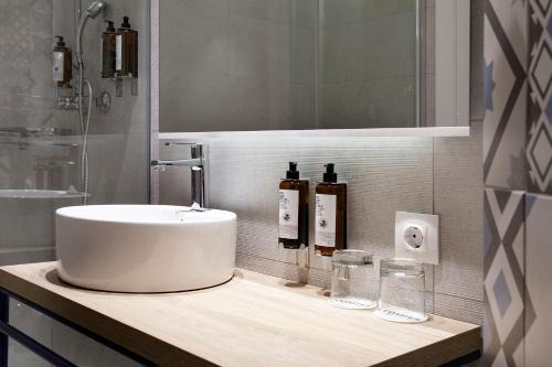 a bathroom with a sink and two bottles on a counter at Petit Palace Ruzafa in Valencia