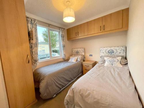 um pequeno quarto com 2 camas e uma janela em Modern House in Carlisle close to Lake District em Carlisle