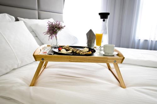 a tray of food on a table on a bed at Plovdiv City Center Hotel in Plovdiv