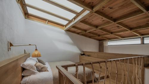 a loft bedroom with a bed and a window at Beevalley Manshan House in Dali