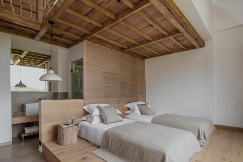 two beds in a large room with wooden ceilings at Beevalley Manshan House in Dali