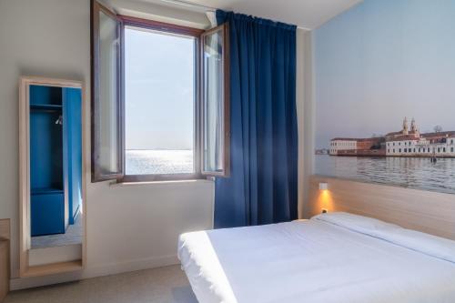 a bedroom with a bed and a large window at Isola di San Servolo - Centro Soggiorno in Venice
