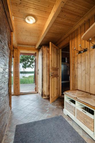 a kitchen with wooden walls and a large window at Vudila saunamaja in Kaiavere
