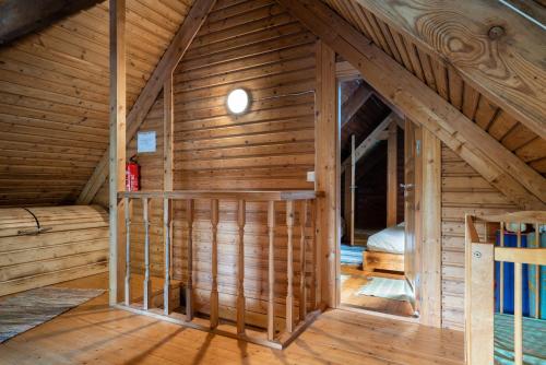 um quarto com uma cama num sótão de madeira em Vudila saunamaja em Kaiavere