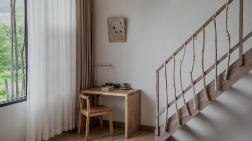 a small table in a room with a staircase at Beevalley Manshan House in Dali