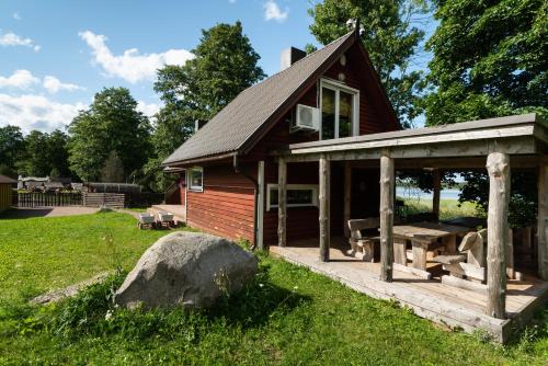a small cabin with a picnic table in the yard at Vudila saunamaja in Kaiavere
