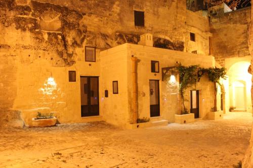 a courtyard in a building with a stone wall at ENOTRIO Barisano in Matera