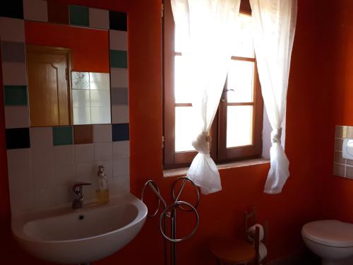 ein Bad mit einem Waschbecken, einem WC und einem Fenster in der Unterkunft Podere Calcinaia in Castelnuovo Berardenga
