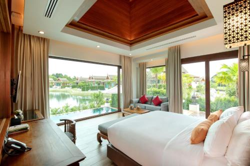 a bedroom with a large bed and a large window at Thantara Resort Chiang Mai in Chiang Mai