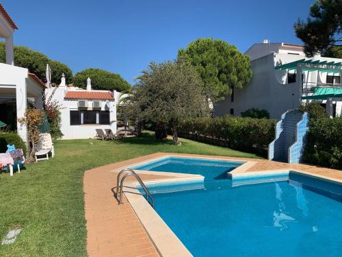 a swimming pool in a yard next to a house at Falésia 25 in Albufeira