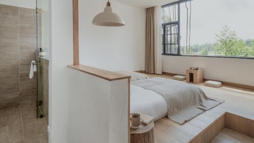 a bedroom with a bed and a shower and a window at Beevalley Manshan House in Dali
