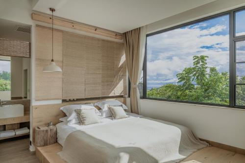 a bedroom with a bed and a large window at Beevalley Manshan House in Dali