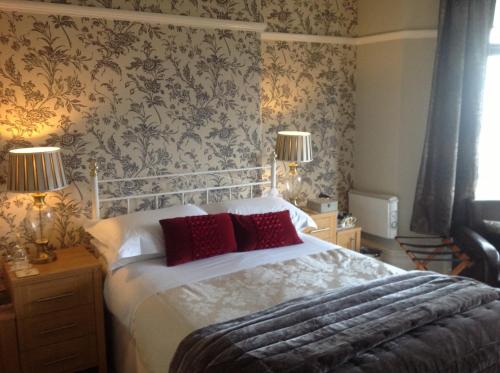 a bedroom with a large bed with red pillows at Yacht Bay View in Morecambe