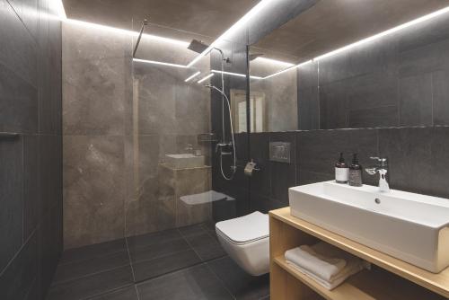 uma casa de banho com um lavatório, um WC e um chuveiro em Forest Resort em Vír