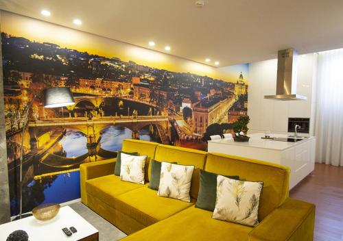 een woonkamer met een gele bank en een schilderij van een stad bij GuimaGold in Guimarães