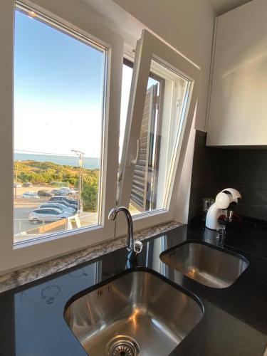 a kitchen with a sink and two windows at Your Home @ Benagil in Lagoa