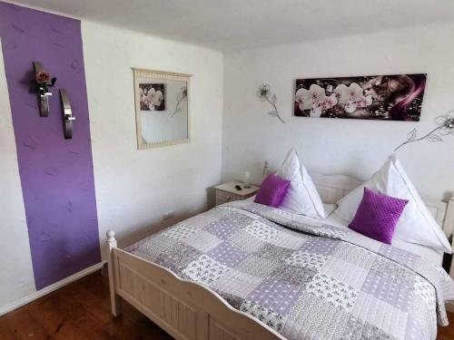 a bedroom with a purple and white bed with purple pillows at Mainschleifenherz in Volkach