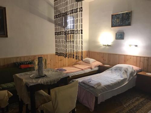 a room with two twin beds and a table with a table sidx sidx at Balogh vendégház II in Szeged