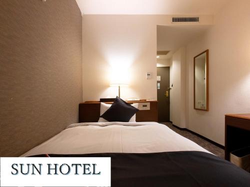 Un pat sau paturi într-o cameră la Sun Hotel Kokubu Kagoshima