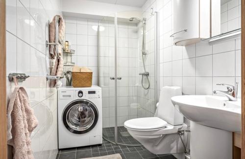 een badkamer met een wasmachine en een wastafel bij Egen lägenhet underbara Käringön möjlighet till parkeringsplats in Käringön