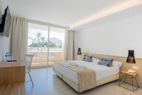 1 dormitorio con cama y ventana grande en Globales Cala Bona, en Cala Bona