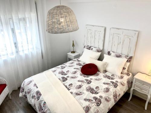 a bedroom with a bed with a red pillow on it at Red Apartment em Fátima a 250m do Santuário in Fátima