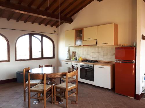 eine Küche mit einem Tisch, einem Herd und einem Kühlschrank in der Unterkunft Podere Calcinaia in Castelnuovo Berardenga