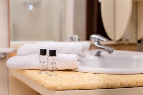 um balcão de casa de banho com toalhas e um lavatório em Almira Orion Group Hotel em Adler