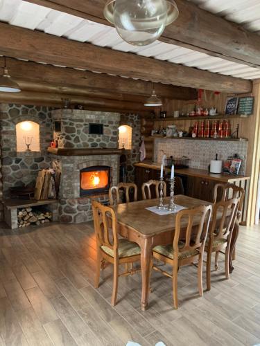 a dining room with a wooden table and a fireplace at Koka Pässä küla Võru vald in Võru