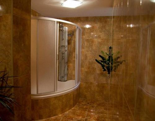 La salle de bains est pourvue d'une douche avec une porte en verre. dans l'établissement Hotel Restauracja Cukropol, à Gostyń