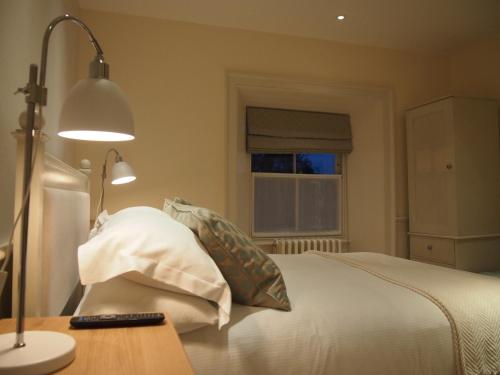 a bedroom with a bed with a lamp and a pillow at Houndgate Townhouse in Darlington