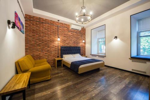 a bedroom with a bed and a chair and a brick wall at Central Dayflat Apartments in Kyiv